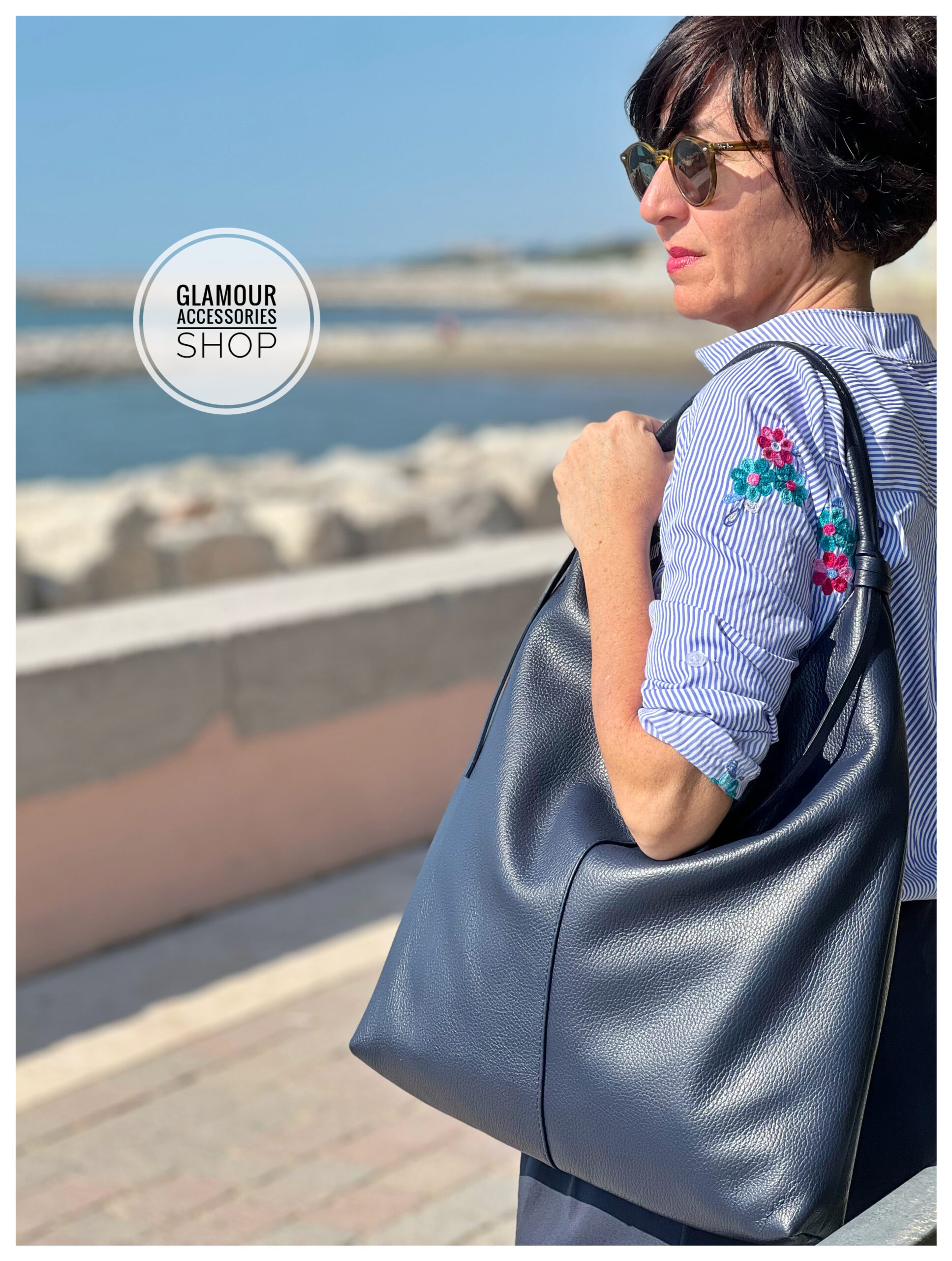 Borsa sacca donna in vera pelle Made in Italy, colore blu, indossata a spalla.