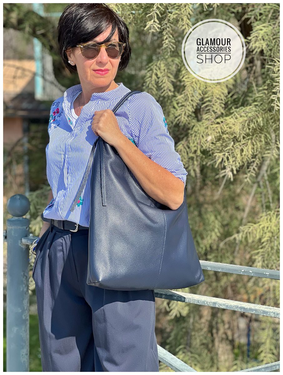 Borsa sacca donna in vera pelle Made in Italy, colore blu, indossata a spalla.